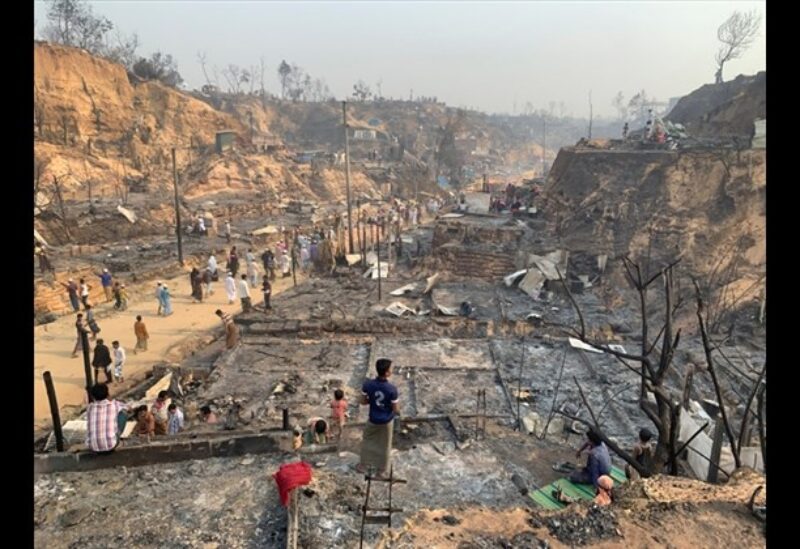 Rohingya refugees look at the remains of Monday's fire at the Rohingya refugee camp in Balukhali