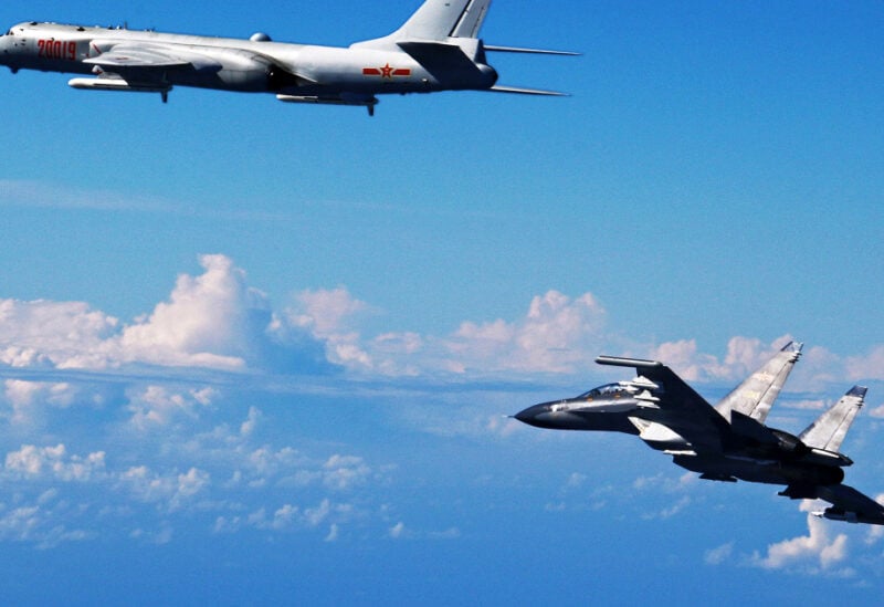 Photo released by Xinhua News Agency, Chinese People's Liberation Army Air Force Su-30 fighter, right, flies along with a H-6K bomber as they take part in a drill near the East China Sea. Japan's top government spokesman has warned China against expanding its military activity in the skies over disputed East China Sea islands after eight Chinese warplanes flew near the area on Sunday. (Shao Jing/Xinhua via AP)