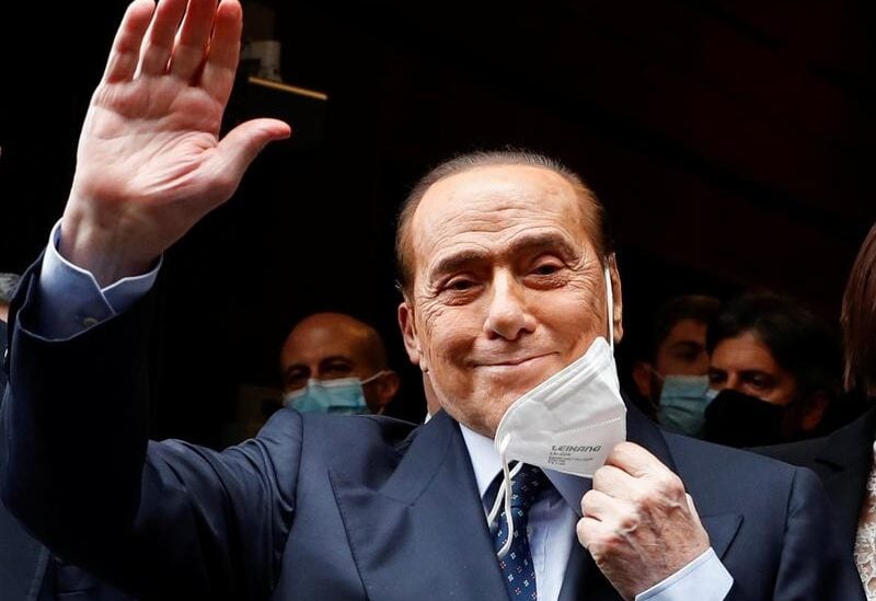 Italy's former Prime Minister Silvio Berlusconi takes out his face mask and waves as he arrives at Montecitorio Palace for talks on forming a new government, in Rome, Italy, February 9, 2021.