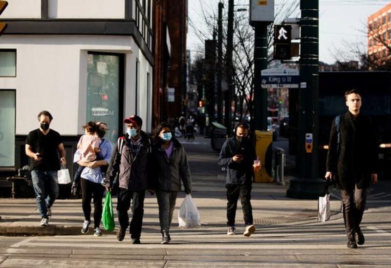 FILE PHOTO: People walk with face masks on the one-year anniversary of the World Health Organization declaring coronavirus disease (COVID-19) a pandemic in Toronto, Ontario, Canada March 11, 2021.