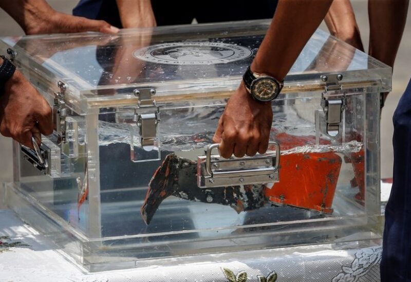 National Transportation Safety Committee (KNKT) officials place the Cockpit Voice Recorder (CVR) of Sriwijaya Air flight SJ 182 on a table at Tanjung Priok Port in Jakarta, Indonesia, March 31, 2021.