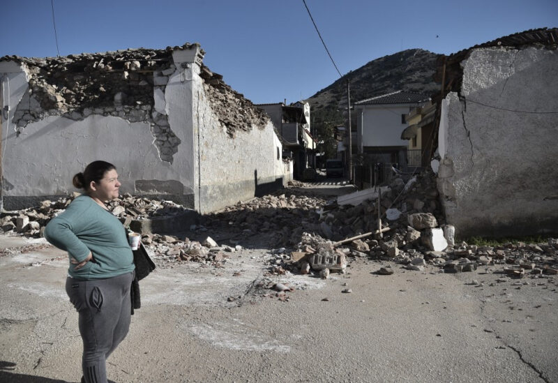 FILE PHOTO: A woman stands by damaged old buildings in the village of Damasi, near the town of Tyrnavos, after a strong 6,3-magnitude earthquake hit the Greek central region of Thessaly on March 3.