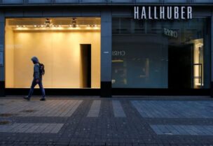 FILE PHOTO: A man walks along a closed shop at the main shopping street Hohe Strasse amid the coronavirus disease (COVID-19) pandemic in Cologne, Germany, March 18, 2021.