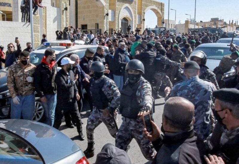 Members of Jordan's police keep demonstrators away outside al-Hussain New Salt Hospital in the town of Salt, northwest of Jordan's capital, on March 13, 2021, as people protest the deaths of of COVID-19 patients who died of lack of oxygen.
