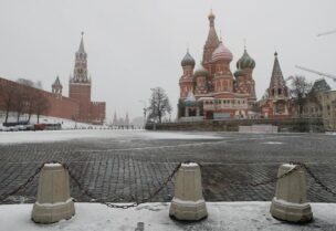 FILE PHOTO: The clock on Spasskaya tower showing the time at noon, is pictured next to Moscow’s Kremlin, and St. Basil’s Cathedral as they stand on an empty square, during the coronavirus disease (COVID-19) outbreak, in Moscow, Russia, March 31, 2020.