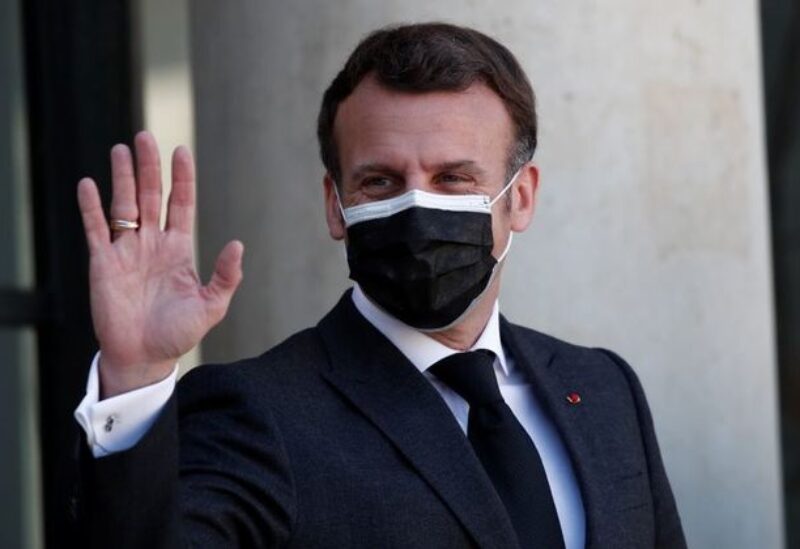 FILE PHOTO: French President Emmanuel Macron, wearing a protective face mask, waves to journalists as he welcomes President of the Kurdistan region in Iraq Nechirvan Barzani (not seen) before a meeting at the Elysee Palace in Paris, France, March 30, 2021.