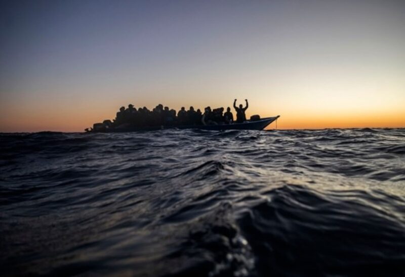 In this Friday, Feb. 12, 2021 file photo, migrants and refugees from different African nationalities wait for assistance on an overcrowded wooden boat, as aid workers of the Spanish NGO Open Arms approach them in the Mediterranean Sea, international waters, at 122 miles off the Libyan coast.