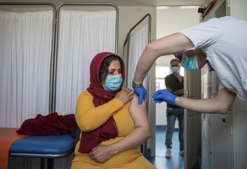 A migrant receives the AstraZeneca vaccine against the coronavirus disease (COVID-19) at a camp for refugees and migrants in Belgrade, Serbia, March 26, 2021.