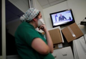 Medical staff members watch French Prime Minister Jean Castex on TV as he addresses the nation about the coronavirus disease (COVID-19) outbreak and the lockdown restrictions, at the Clinique de l'Estree - ELSAN private hospital in Stains, near Paris, France, March 18, 2021.