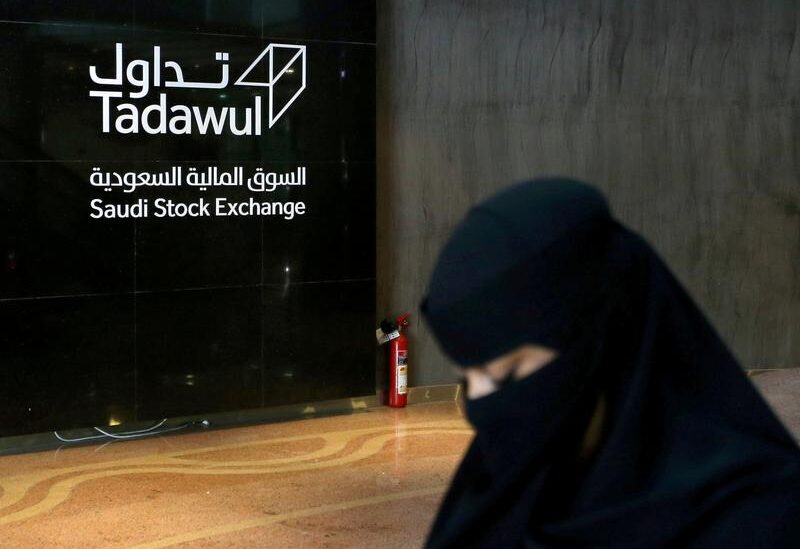 FILE PHOTO: Saudi woman walks at the Saudi stock market (Tadawul), in Riyadh, Saudi Arabia March 9, 2020.