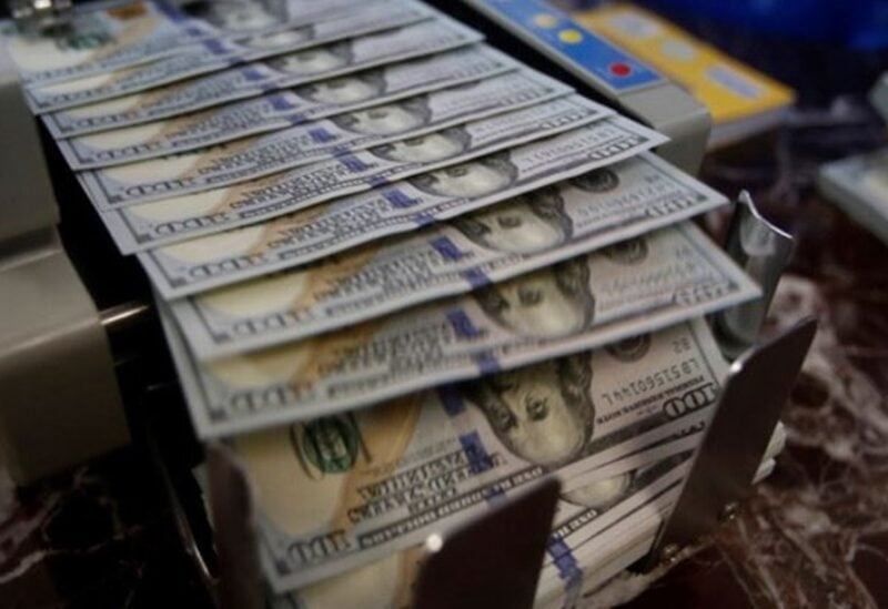 U.S. dollar banknotes coming out of a money counting machine.