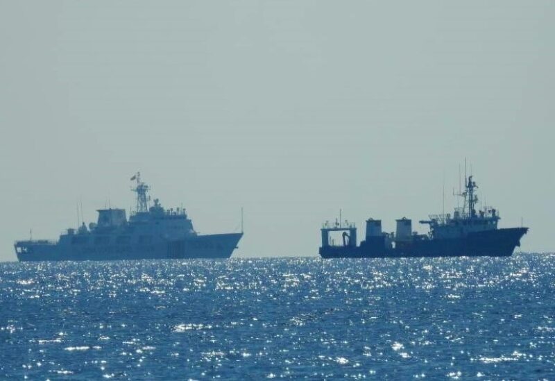 A Chinese Coast Guard patrol ship (L) is seen near an unidentified vessel at South China Sea, in a handout photo distributed by the Philippine Coast Guard April 15 and taken according to the source either on April 13 or 14, 2021. Philippine Coast Guard/Handout via REUTERS