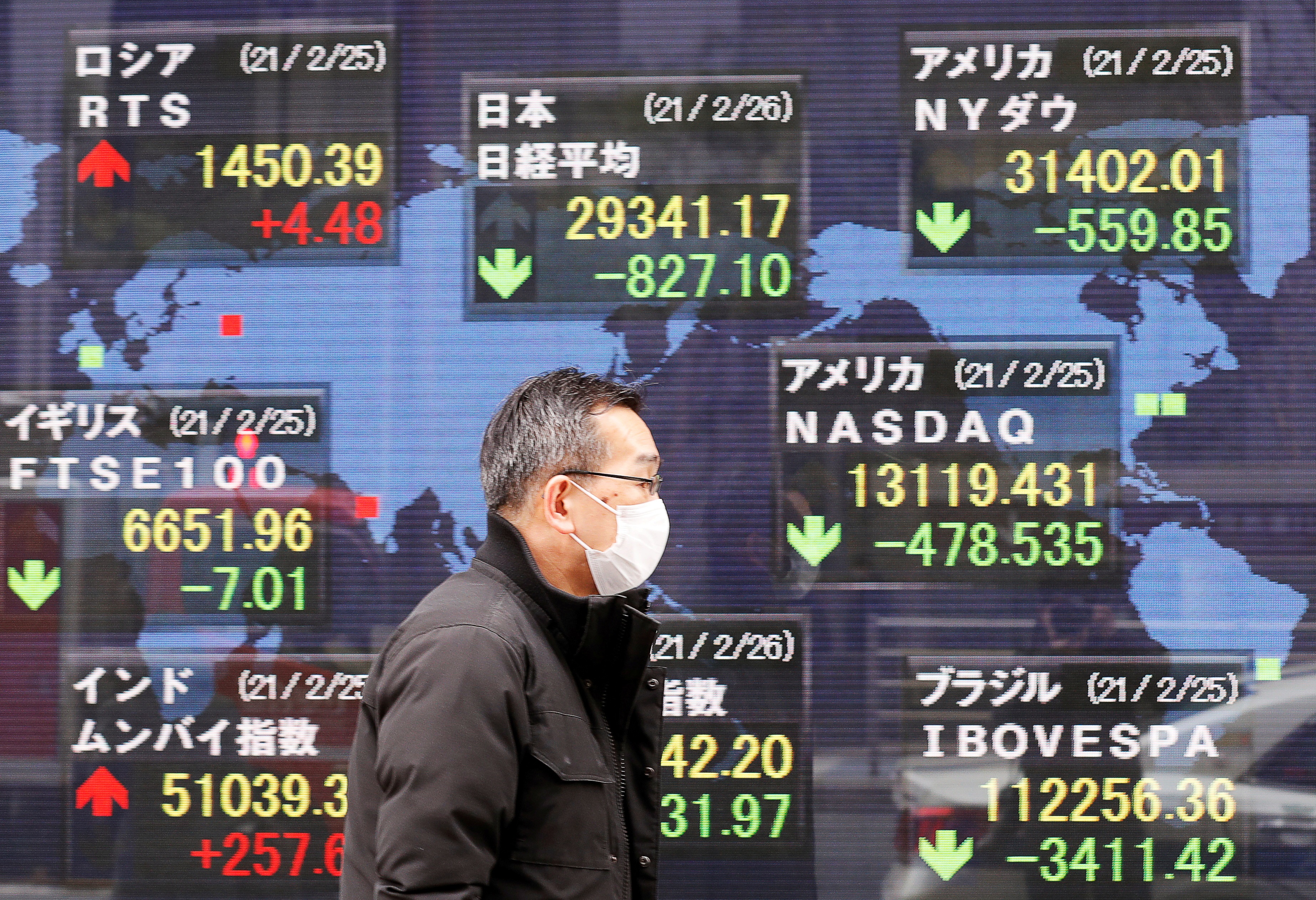 A man walks past a stock quotation board at a brokerage in Tokyo, Japan February 26, 2021. REUTERS