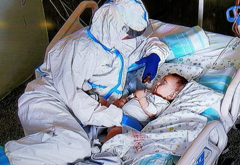 A nurse comforts a seven-month-old baby at the Salesi Hospital following an operation after his parents were unable to visit due to coronavirus restrictions, in Ancona, Italy, March 22, 2021.