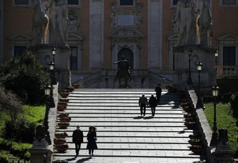 FILE PHOTO: People wearing protective face masks walk as Rome becomes a 'red zone', going into lockdown, as the country struggles to reduce the coronavirus disease (COVID-19) infections, in Rome, Italy, March 15, 2021.