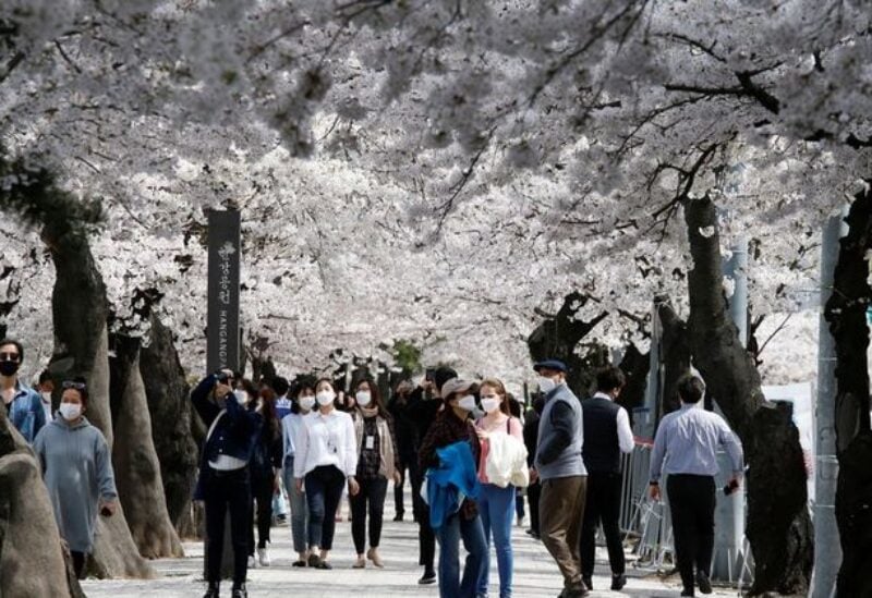 FILE PHOTO: People walk near a cherry blossom street, closed to avoid the spread of the coronavirus disease (COVID-19), in Seoul, South Korea, April 1, 2021.