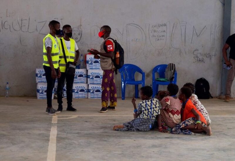 FILE PHOTO: People, who fled an attack claimed by Islamic State-linked insurgents on the town of Palma, look on as aid workers consult a person at a displacement centre in Pemba, Mozambique, April 2, 2021.