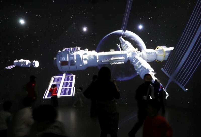 Visitors stand near a giant screen displaying the images of the Tianhe space station at an exhibition featuring the development of China's space exploration on the country's Space Day at China Science and Technology Museum in Beijing, China April 24, 2021. REUTERS