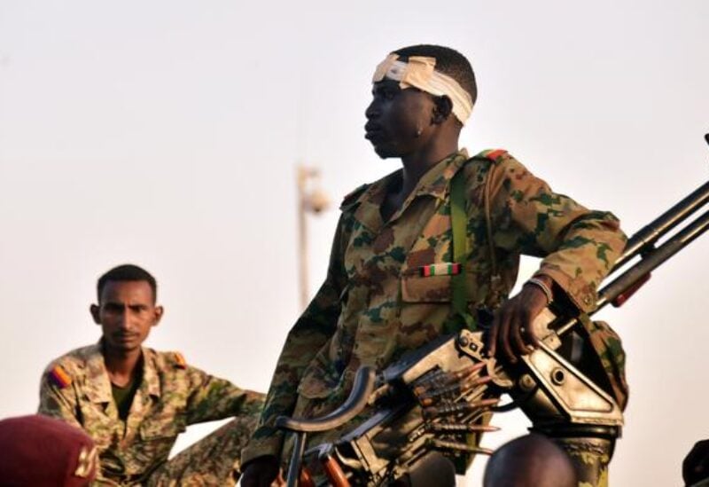 FILE PHOTO: Sudanese military soldiers look on as demonstrators attend a protest demanding Sudanese President Omar Al-Bashir to step down outside the defense ministry in Khartoum, Sudan April 8, 2019.