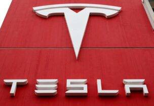 FILE PHOTO: The logo of car manufacturer Tesla is seen at a branch office in Bern, Switzerland October 28, 2020.
