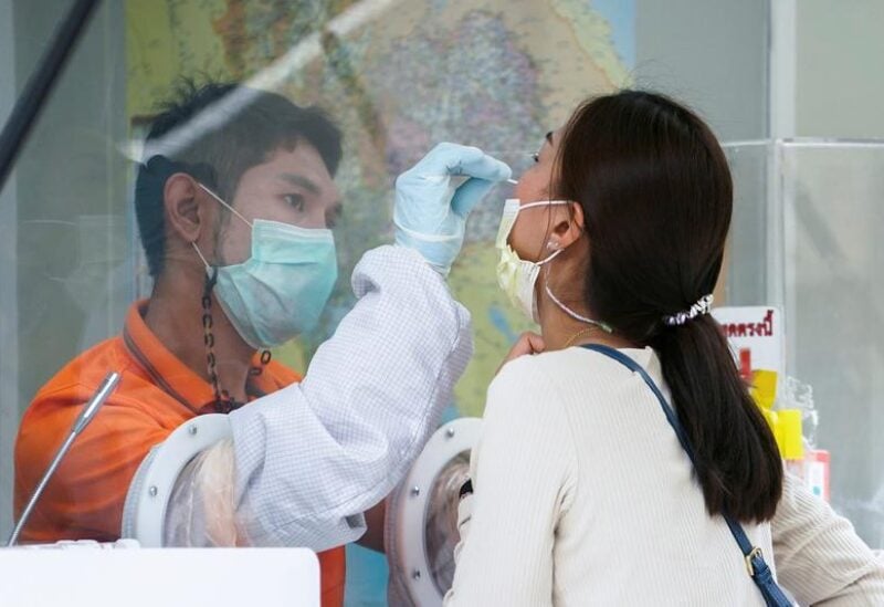 FILE PHOTO: A healthcare worker takes a nasal swab sample from a local resident for a COVID-19 test after hundreds of residents of Watthana district and the trendy Thonglor neighborhood tested positive for the coronavirus disease (COVID-19) in Bangkok, Thailand, April 8, 2021.