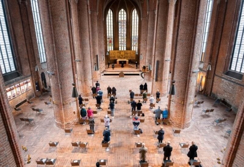 Worshipers celebrate a Good Friday service at the Marktkirche on Hanover, Germany, Friday, April 2, 2021. Despite the Corona pandemic and numerous contact restrictions, the churches are allowed to celebrate services around Easter.