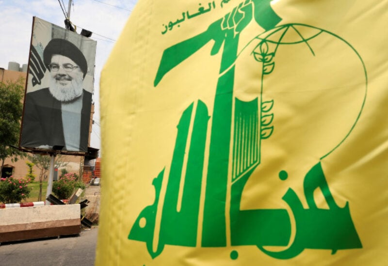 A Hezbollah flag and a poster depicting Lebanon's Hezbollah leader Sayyed Hassan Nasrallah are pictured along a street, near Sidon, Lebanon July 7, 2020. REUTERS