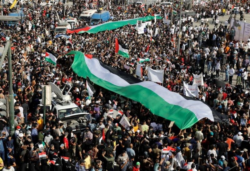 Iraqi demonstrators wave giant Palestinian flags during a protest to express solidarity with the Palestinian people amid a flare-up of Israeli-Palestinian violence, in Baghdad, Iraq May 15, 2021. REUTERS