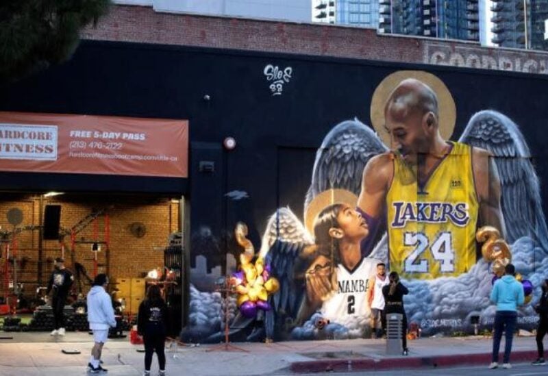 People stop by a mural of late Kobe Bryant, who perished one year ago alongside his daughter and seven others when their helicopter crashed into a hillside, in Los Angeles, California, U.S., January 26, 2021. REUTERS