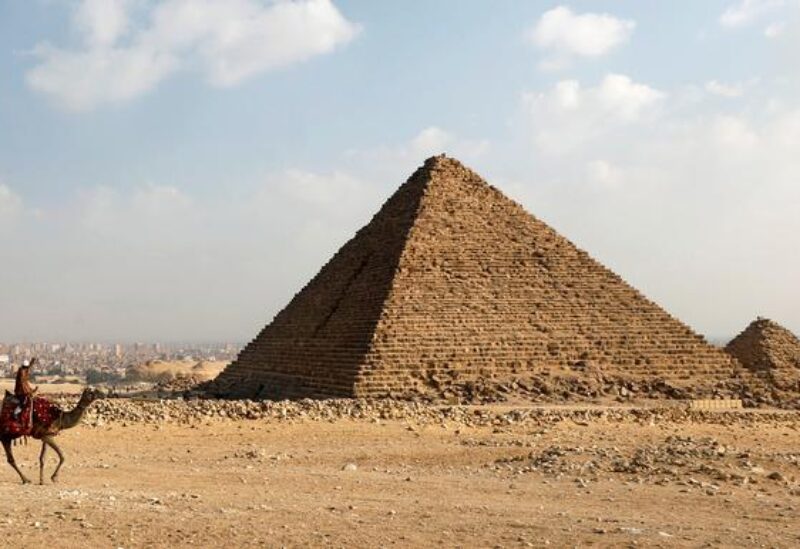 A camel guide waits for customers next to the pyramid of Khafre or "Chefren" at the Giza pyramids plateau in Giza, Egypt December 18, 2020. REUTERS