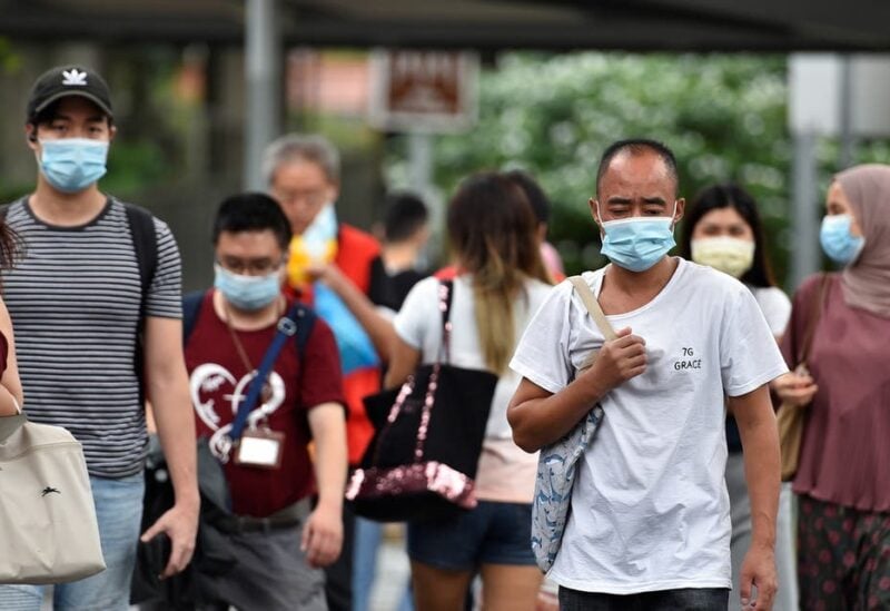 People wearing face masks cross a road amid the coronavirus disease (COVID-19) outbreak in Singapore May 14, 2021. (Reuters)