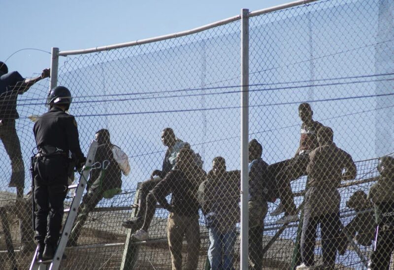 African migrants sit on top of a border fence during an attempt to cross into Spanish territories, between Morocco and Spain's north African enclave of Melilla, November 21, 2015. (File photo: Reuters)