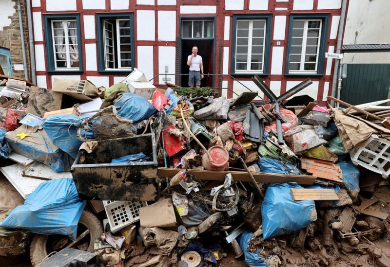 A man looks on outside a house in an area affected by floods caused by heavy rainfalls in Bad Muenstereifel, Germany, July 19, 2021. REUTERS/Wolfgang Rattay/File Photo