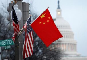 The People's Republic of China flag and the U.S. flag fly on a lamp post along Pennsylvania Avenue near the U.S. Capitol in Washington during then-Chinese President Hu Jintao's state visit, January 18, 2011. REUTERS/Hyungwon Kang/File Photo
