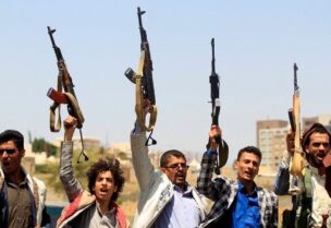 Yemeni fighters loyal to the Iran-backed Houthis raise their weapons during a rally in the capital Sanaa, on May 20, 2021. (AFP)
