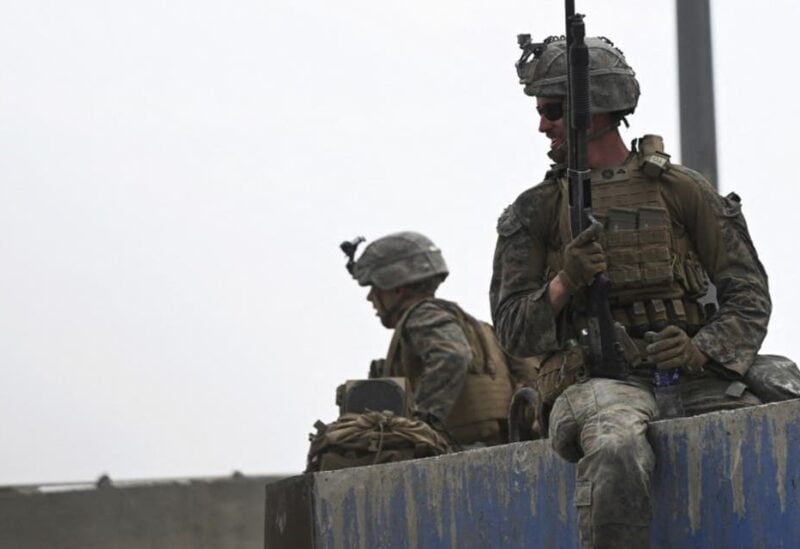 US soldiers sit on a wall as Afghans gather on a roadside near the military part of the airport in Kabul on August 20, 2021. (File photo: AFP)