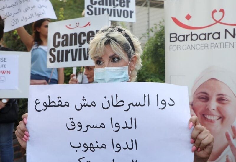 Christine Tohme, a cancer patient, holds a sign during a sit-in demonstration as shortages of cancer medications spread, in front of the UN headquarters in Beirut, Lebanon, on August 26, 2021. (Reuters)