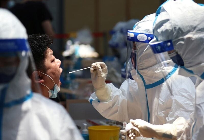A medical worker in protective suit collects a swab from a resident for nucleic acid testing at a sports centre in Jiangning district, following new cases of the coronavirus disease (COVID-19) in Nanjing, Jiangsu province, China July 21, 2021. (Reuters)