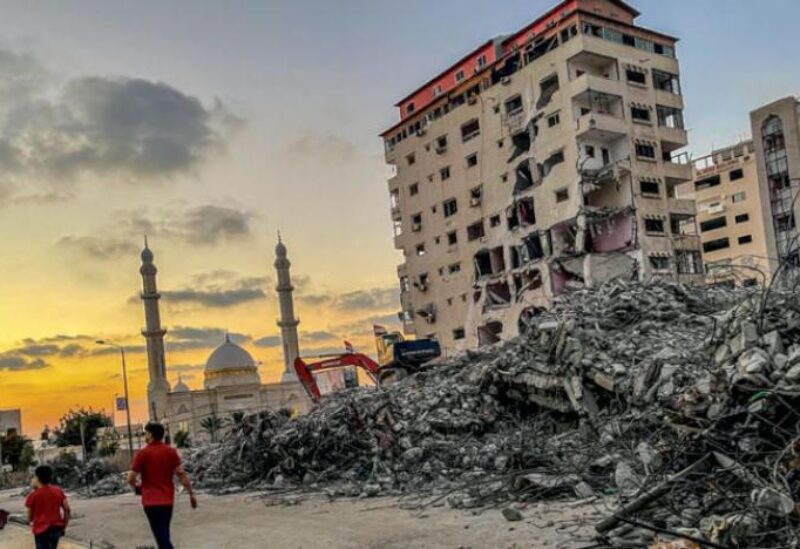 Egyptian workers remove the rubble of buildings destroyed during latest war in Gaza