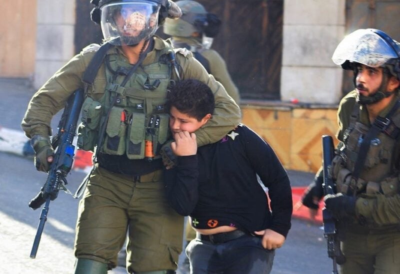 Israeli soldiers detain a Palestinian boy during clashes in Hebron, in the Israeli-occupied West Bank on September 23, 2021. (Reuters)