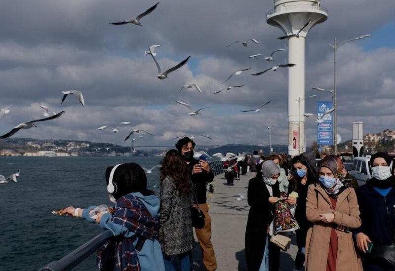 People wearing protective masks stroll by the Bosphorus, amid the coronavirus disease (COVID-19) outbreak in Istanbul, Turkey. (Reuters)