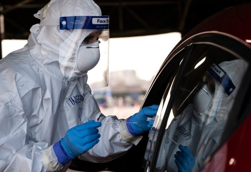 A military medical worker collects on January 12, 2021 a swab sample from a person going through a drive-in swab testing center for COVID-19 set up by the army on the parking lot of the Juventus stadium in Turin, Italy. (Marco Bertorello/AFP)