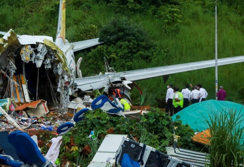 Officials inspect the wreckage of an Air India Express jet at Calicut International Airport in Karipur, Kerala, on August 8, 2020. (AFP)