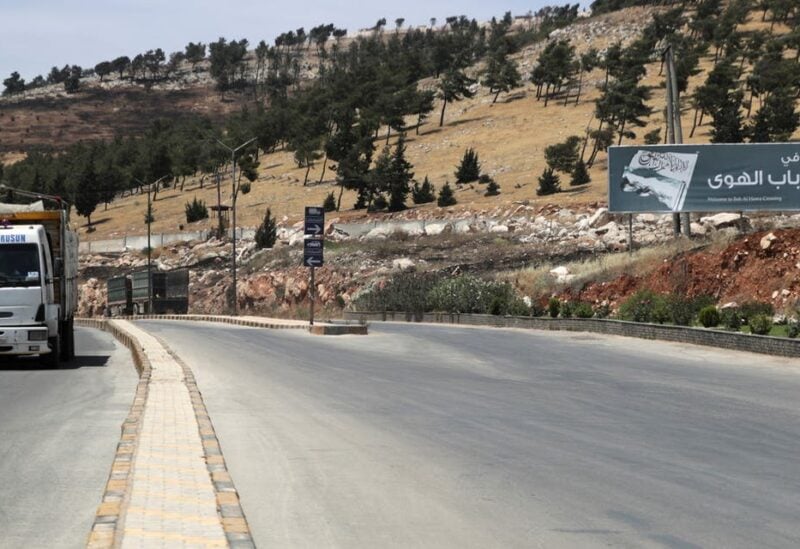 A vehicle drives past a road sign that reads Welcome to Bab al-Hawa crossing, at Bab al-Hawa crossing at the Syrian-Turkish border, in Idlib governorate, Syria June 10, 2021. (Reuters)
