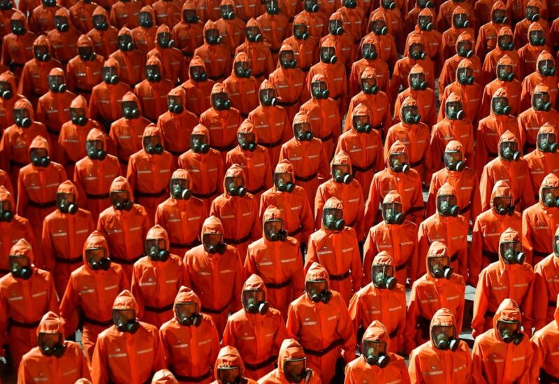 Personnel in orange hazmat suits march during a paramilitary parade held to mark the 73rd founding anniversary of the republic at Kim Il Sung square in Pyongyang in this undated image supplied by North Korea's Korean Central News Agency on September 9, 2021. (Reuters)