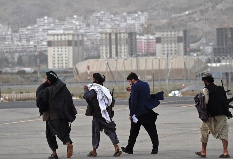 Taliban fighters walk through the tarmac after a Qatar Airways aircraft took off from the airport in Kabul on Sept. 9, 2021. (AFP)