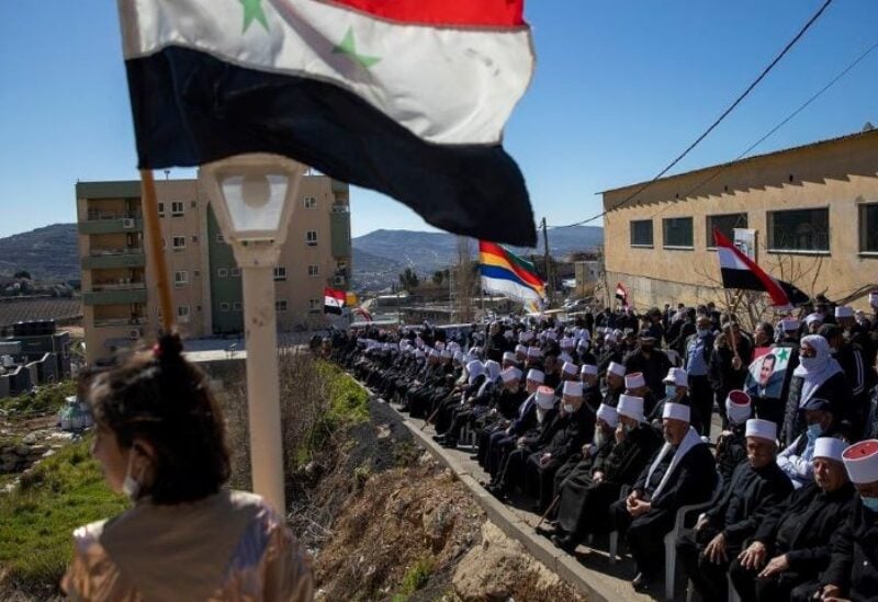 In this Feb. 14, 2021 file photo, Druse supporters of Syrian President Bashar Assad wave Syrian flags during a rally close to the border demanding the return of the Golan Heights
