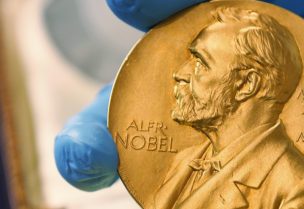 FILE - In this April 17, 2015 file photo, a national library employee shows a gold Nobel Prize medal. The Nobel Peace Prize will be awarded on Friday Oct. 8, 2021. (AP Photo/Fernando Vergara, File)