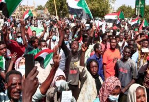 Sudanese demonstrators raise national flags