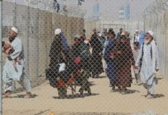 ِِAfghan people walk inside a fenced corridor as they enter Pakistan at the Pakistan-Afghanistan border crossing point in Chaman